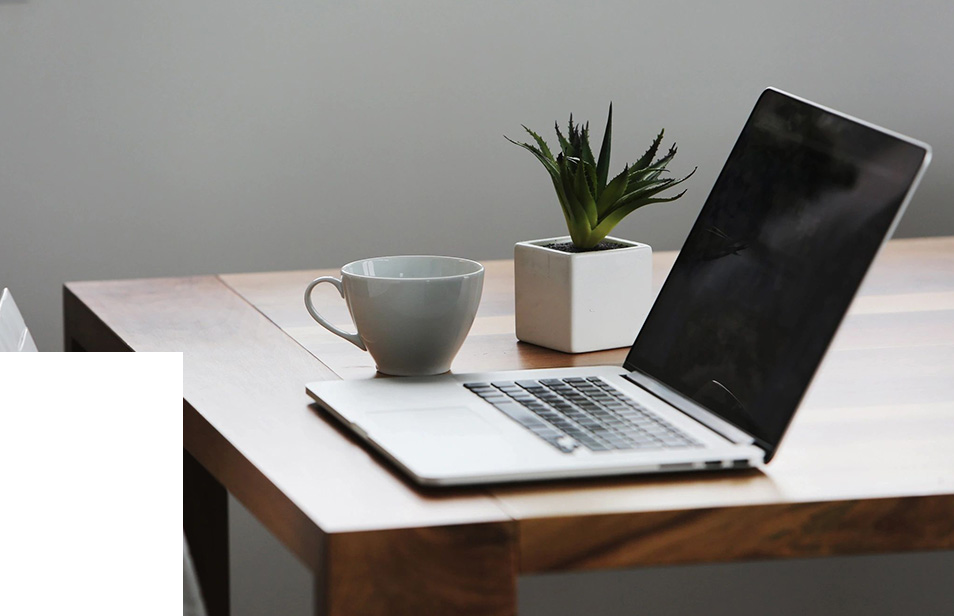 A laptop and cup on a table